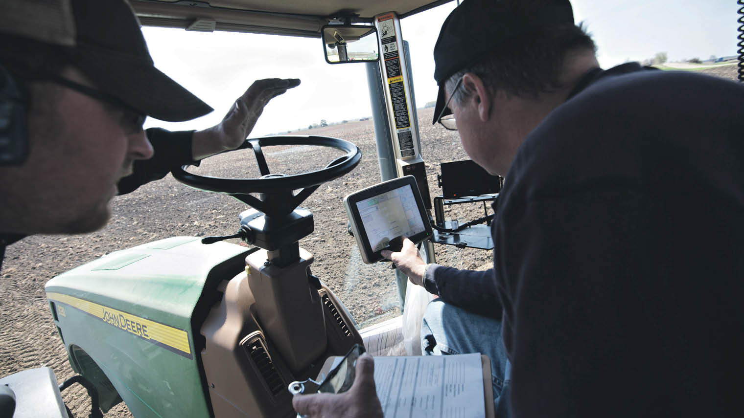 Farmers using tablet in tractor
