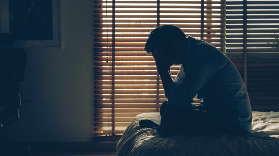 Sad Businessman Sitting Head In Hands On The Bed In The Dark Bedroom With Low Light Environment, Dramatic Concept, Vintage Tone Color